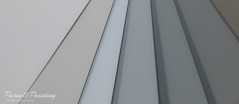 a fan of paint chip samples in tones of gray and blue