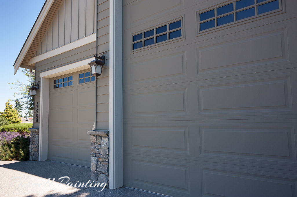 Overhead garage doors painted green-grey Sherwin Williams Hardware and the trim with Grecian Ivory trim work on a large house in Nanaimo