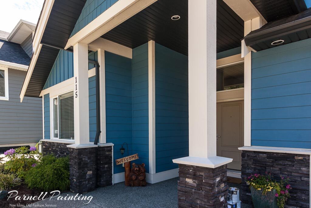 An Exterior house painted in Sherwin Williams Inky Blue showing how much brighter and vibrant it appears compared to the paint chip sample.